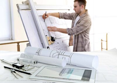 Table with construction drawings and architect working on blueprints