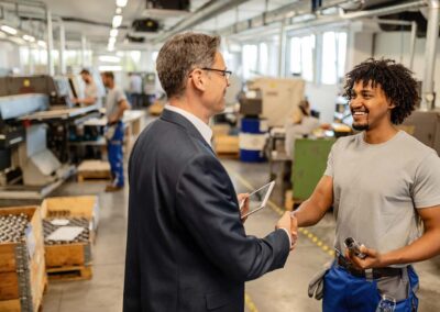 Woodworker greeting his manager in wood shop